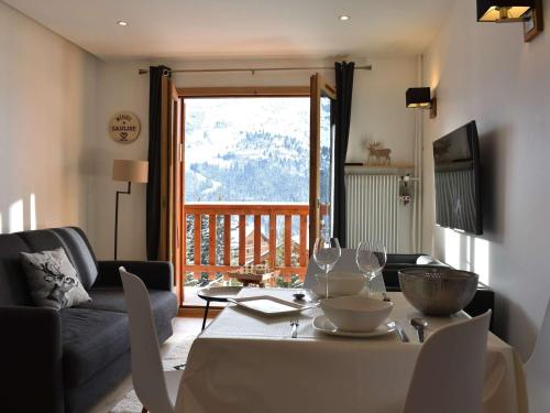 - un salon avec une table et des verres à vin dans l'établissement Charmant 2 pièces pour 4 à Méribel, à proximité des pistes, commerces et navette - FR-1-180-368, à Les Allues