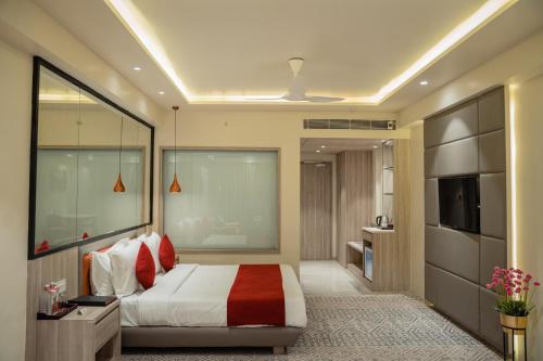 a bedroom with a large bed and a television at Lords Inn Rajkot in Rajkot