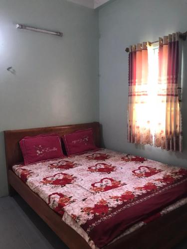 um quarto com uma cama com um edredão vermelho e branco em Nhà Nghỉ Bình Dân Xanh em Bắc Quang
