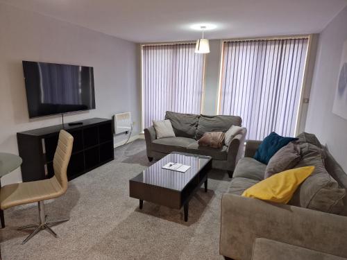 a living room with a couch and a tv at Coventry Home in Coventry