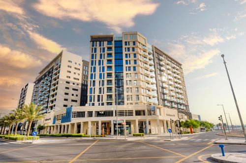 a large building on a street with a parking lot at Expo Village Serviced Apartments in Dubai