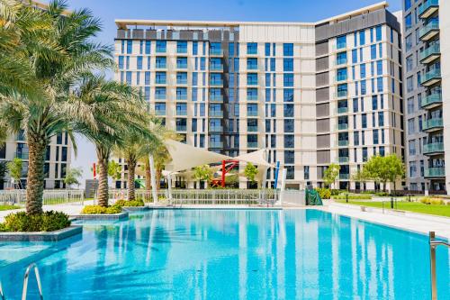 una gran piscina frente a un gran edificio en Expo Village Serviced Apartments, en Dubái