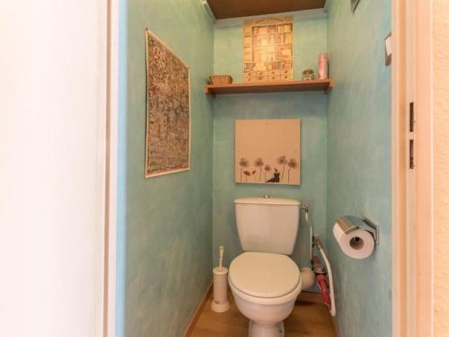 La salle de bains est pourvue de toilettes blanches dans un mur bleu. dans l'établissement Charmant studio à Chantemerle, terrasse, jardin, parking gratuit, 4 pers, proche Serre-Chevalier - FR-1-330E-53, à Saint-Chaffrey