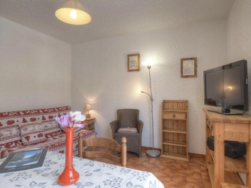 un salon avec un vase de fleurs sur une table dans l'établissement Studio cosy pour 2, Serre-Chevalier Chantemerle - Proche pistes, parking, casier à ski, animaux acceptés - FR-1-330E-62, à Saint-Chaffrey
