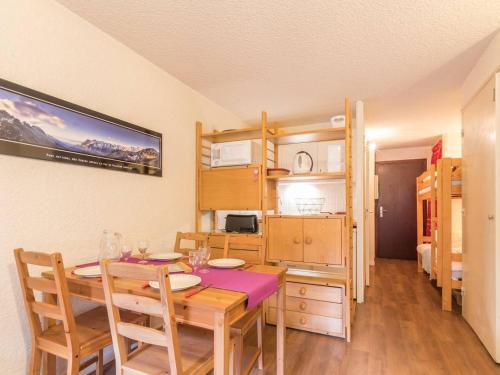 une salle à manger avec une table et une cuisine dans l'établissement Charmant studio ski-in/ski-out 4 pers. avec piscine, jardin et parking à La Salle les Alpes - FR-1-330F-62, à Serre Chevalier