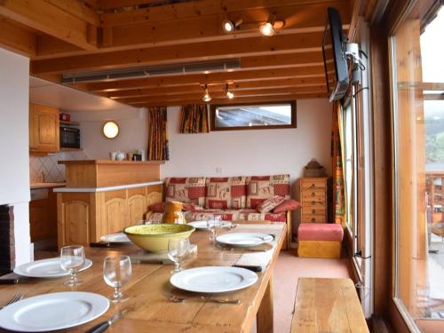 une cuisine avec une table en bois et des plaques de cuisson. dans l'établissement Charmant 2 pièces mezzanine, 6 pers, centre Méribel, proche pistes et commerces - FR-1-180-364, à Les Allues