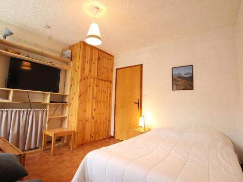 une chambre avec un lit et une télévision à écran plat dans l'établissement Studio cosy pour 2 à Chantemerle, Serre-Chevalier - Tout équipé, TV, Wifi et options confort - FR-1-330E-63, à Saint-Chaffrey