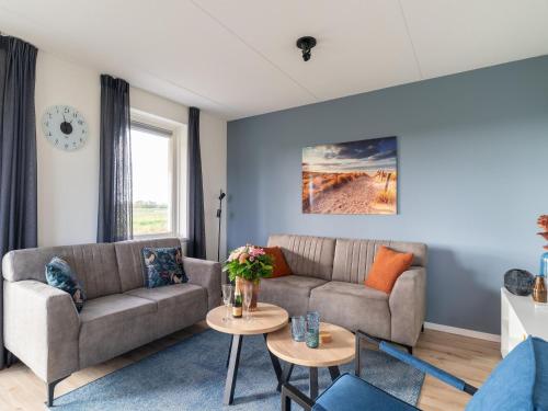 uma sala de estar com dois sofás e uma mesa em Modern holiday home by the sea with sauna em Scherpenisse