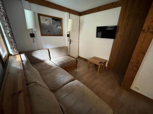 uma sala de estar com um sofá e uma mesa em Superbe Appartement à Montchavin em Montchavin