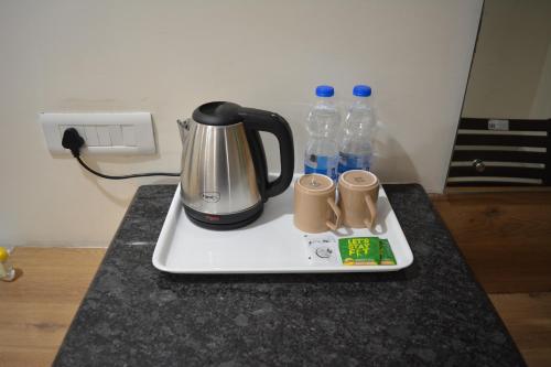 a tea kettle and two bottles of water on a counter at Hotel Ambicas Grand in Visakhapatnam