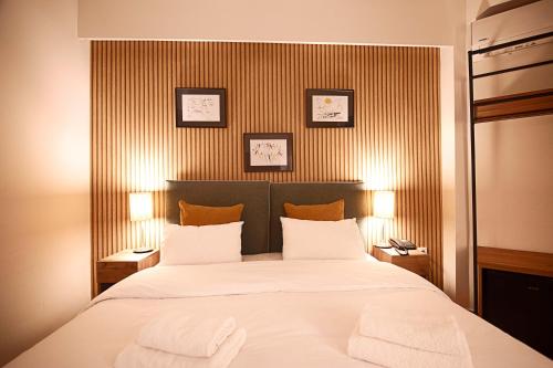 sypialnia z dużym łóżkiem z dwoma ręcznikami w obiekcie FALIREON HOTEL w Atenach