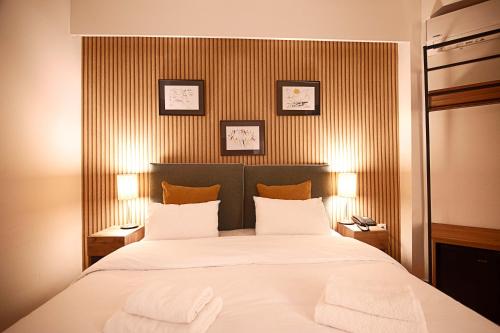 una camera da letto con un grande letto con due asciugamani di FALIREON HOTEL ad Atene