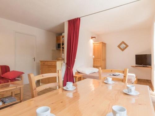 Il dispose d'une cuisine et d'un salon avec une table et des chaises en bois. dans l'établissement Studio cosy à la montagne pour 5 personnes à Chantemerle - Serres-Chevalier - FR-1-330E-40, à Saint-Chaffrey