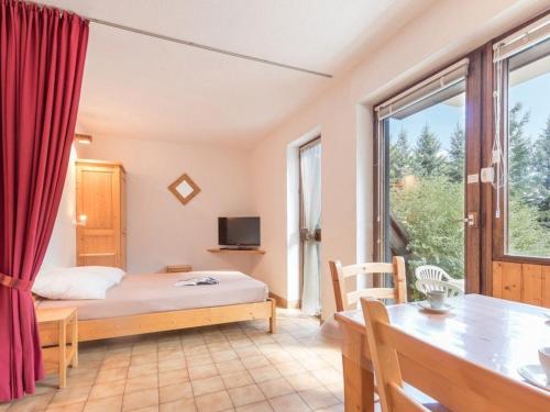 une chambre avec un lit, une table et une fenêtre dans l'établissement Studio cosy à la montagne pour 5 personnes à Chantemerle - Serres-Chevalier - FR-1-330E-40, à Saint-Chaffrey