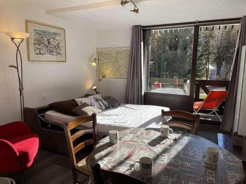 une chambre avec un lit, une table et des chaises dans l'établissement Appartement à Saint-Chaffrey: Terrasse Sud, 4 Couchages, Parking, Casier à Ski - FR-1-330E-47, à Saint-Chaffrey