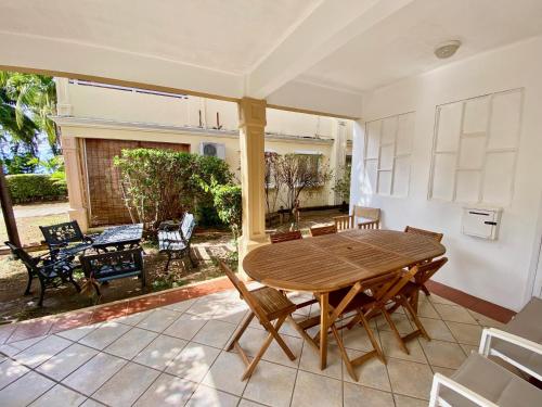 a dining room with a wooden table and chairs at Beachfront Villa in a beautiful and secured complex in Flic-en-Flac