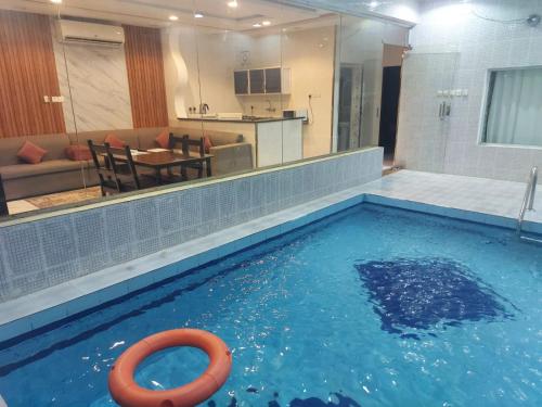 een zwembad met een levensredder in een woonkamer bij شاليهات سويت هوم الدرب الكدره in Ad Darb