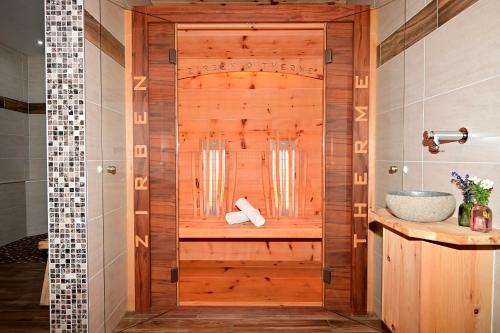 a bathroom with a wooden shower with a sink at Das ALPSPITZ in Biberwier