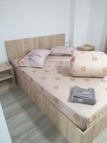 a large bed with a wooden frame and pillows at Pensiunea Valea Veveritelor in Curtea de Argeş