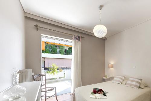 1 dormitorio con cama, mesa y ventana en Central Halandri apartment near all hospitals en Atenas