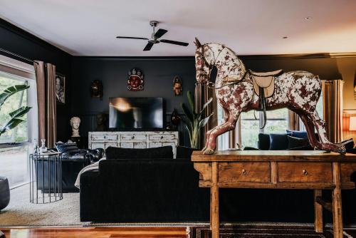 a living room with a statue of a horse on a table at Istana Lodge - Daylesford Region in Musk Vale