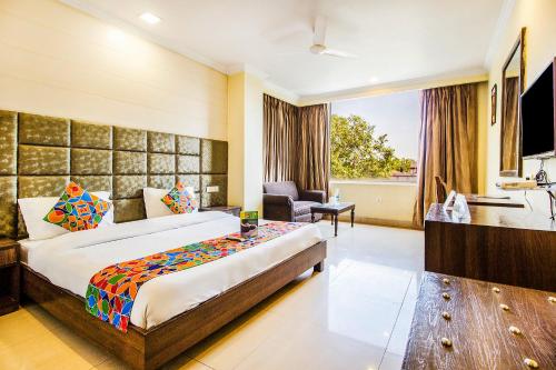 a hotel room with a large bed and a bathroom at FabHotel Aaykay Model Town in Amritsar