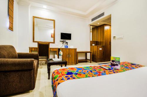 a room with a bed and a couch and a chair at FabHotel Aaykay Model Town in Amritsar
