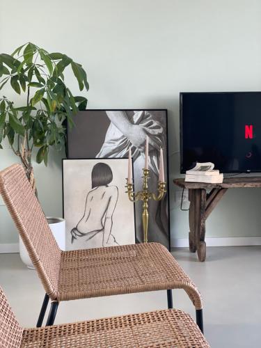 a wicker chair in a living room with a picture at Cocciu d’amuri in Terrasini