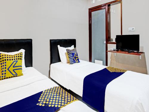 Un pat sau paturi într-o cameră la SPOT ON 91932 Guest House Mustika Syariah