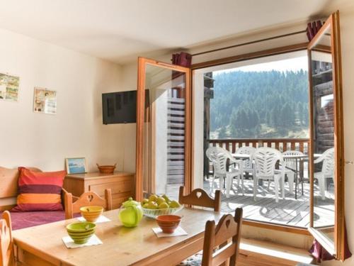 une salle à manger avec une table et une vue sur une terrasse dans l'établissement Studio avec terrasse ensoleillée face aux pistes, animaux acceptés, Montgenèvre - FR-1-266-86, à Montgenèvre