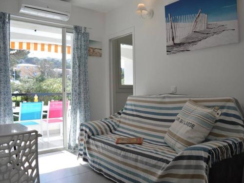 un salon avec un canapé et une porte coulissante en verre dans l'établissement Appartement 2P cabine rénové, clim, wifi, terrasse, parking, proche plage - Sainte-Maxime - FR-1-226-304, à Sainte-Maxime
