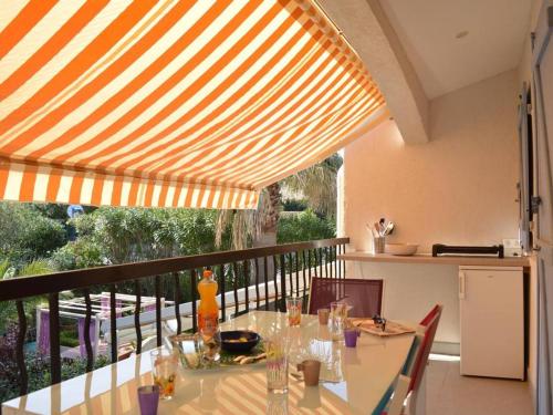 - une salle à manger avec une table sous un auvent dans l'établissement Appartement 2P cabine rénové, clim, wifi, terrasse, parking, proche plage - Sainte-Maxime - FR-1-226-304, à Sainte-Maxime