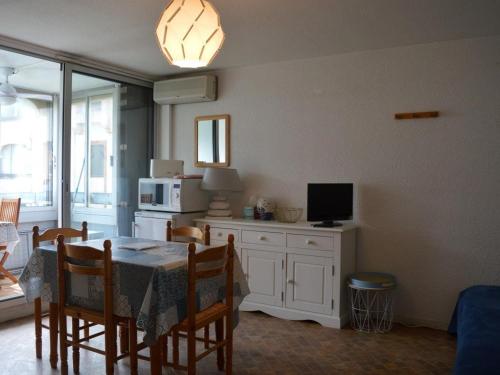 une cuisine et une salle à manger avec une table et une télévision dans l'établissement Appart 2P 4 Pers avec Clim, Parking, à 200m de la plage - FR-1-225D-94, à Saint Cyprien Plage
