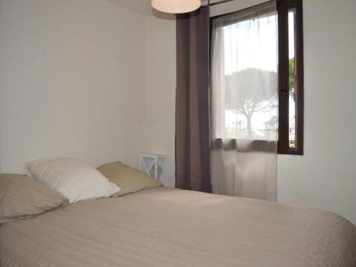 une chambre avec un lit blanc avec une fenêtre dans l'établissement Appart 2P 4 Pers avec Clim, Parking, à 200m de la plage - FR-1-225D-94, à Saint Cyprien Plage