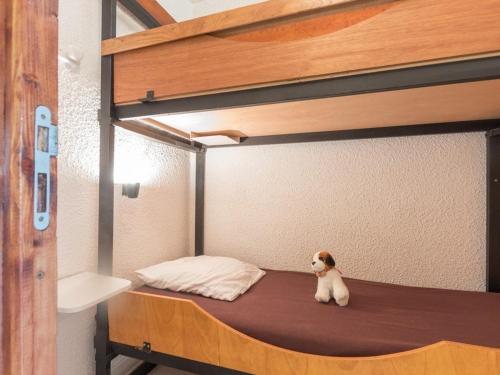 un chien assis sur la couchette inférieure d'un lit superposé dans l'établissement Charmant Studio 4 Pers. avec Balcon à Serre-Chevalier, Parking Inclus - FR-1-330E-11, à Saint-Chaffrey