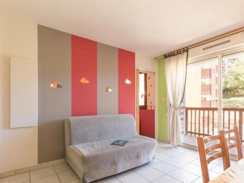 un salon avec une chaise et un mur rayé dans l'établissement Appartement cosy 4 pers à Chantemerle avec balcon, parking, proche pistes de Serre-Chevalier! - FR-1-330E-12, à Saint-Chaffrey