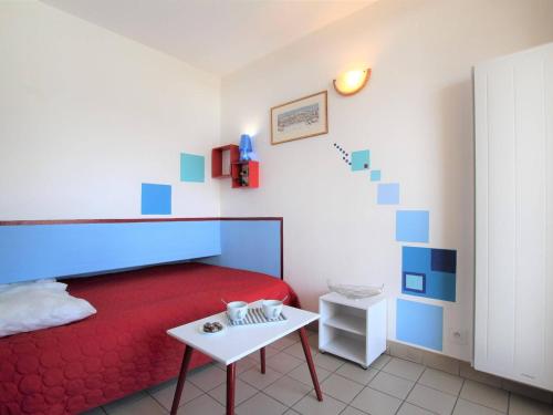- une chambre avec un lit rouge et une table blanche dans l'établissement Apt 2P 4-6 Pers Briançon Proche Pistes, Balcon, TV, Cuisine Équipée, Animaux Admis - FR-1-330C-17, à Briançon