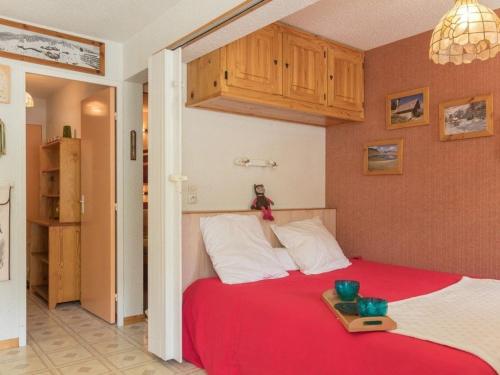 Un dormitorio con una cama roja y una bandeja. en Appartement Puy-Saint-Vincent, 2 pièces, 6 personnes - FR-1-330G-53 en Puy-Saint-Vincent