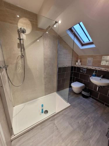 uma casa de banho com um chuveiro, um WC e um lavatório. em 3 Laurel Court em Ulverston