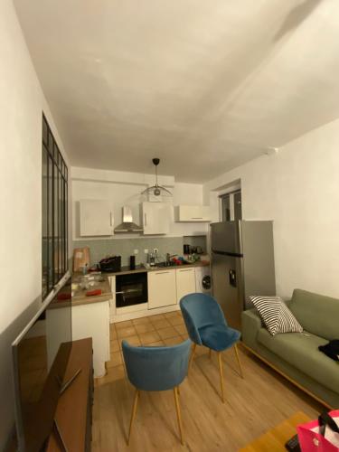 eine Küche und ein Wohnzimmer mit einem Sofa und einem Tisch in der Unterkunft Appartement deux chambres - Garibaldi in Lyon