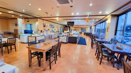 un comedor con mesas y sillas en un restaurante en Hotel Aso No Tsukasa, en Aso
