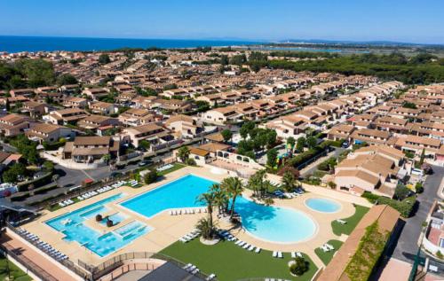 une vue aérienne d'un complexe avec deux piscines dans l'établissement Spacieuse Maison d'angle dans domaine des TAMARIS 5 pièces 6 á 7 couchages WIFI- Accès payant pour piscines-animation - PORTIRAGNES PLAGE LRTAMJ37, à Portiragnes