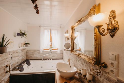 a bathroom with a tub and a sink and a mirror at Altes Häusle am Waschbach-Weinberg in Edenkoben