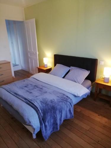 a bedroom with a large bed with two night stands at Jolie maison à 200 m des plages du débarquement in Saint-Aubin-sur-Mer