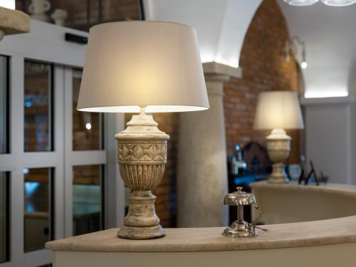 a lamp on a table in a bathroom with a tub at Arkady Hof Hotel in Stupava