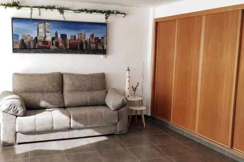 sala de estar con sofá y armario de madera en Precioso apartamento en el Faro de Cullera en Faro de Cullera