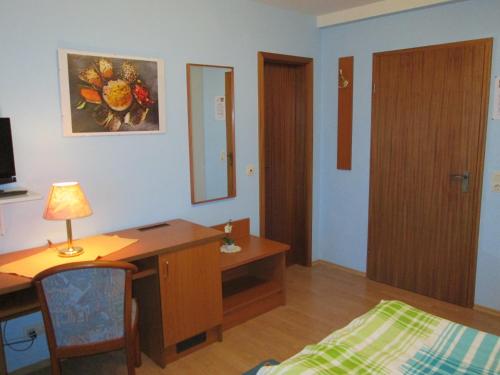 a room with a desk and a bed and a desk and a desk at Pension Weinhaus Unger in Schwenningen