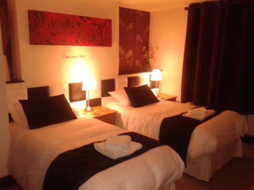 a hotel room with two beds and two lamps at Jasmine House in Lutterworth