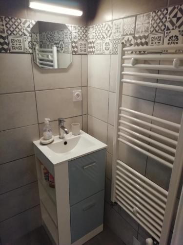 a small bathroom with a sink and a shower at Jolie maison à 200 m des plages du débarquement in Saint-Aubin-sur-Mer
