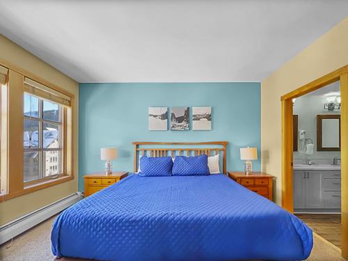 a blue bedroom with a bed and a sink at PP403 Passage Point condo in Copper Mountain